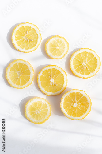 Sliced lemon on a white background . Lemon layout. Sliced fruit. Yellow color. White background. Light and shadow. Citrus. Copy space
