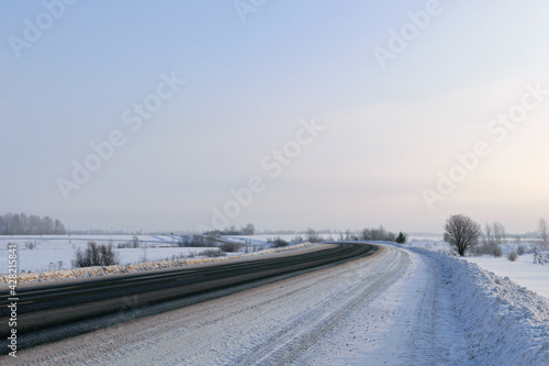 Road through snowy winter fields