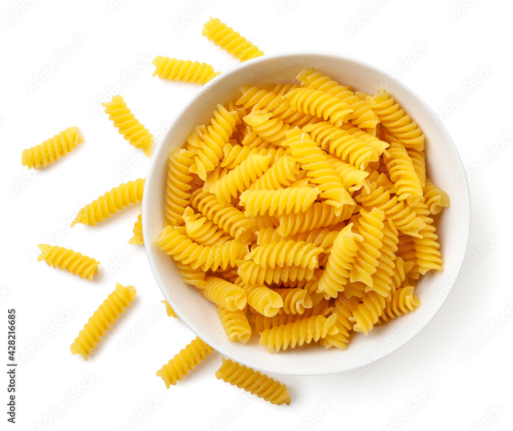 Raw spiral pasta in a plate on a white background, isolated. The view from top Raw spiral pasta in a plate on a white background, isolated. The view from top
