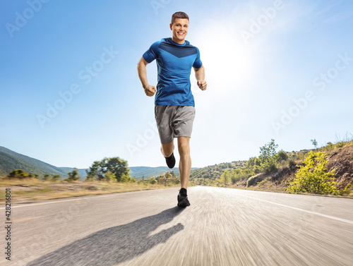 Young man running outdoors on an open road