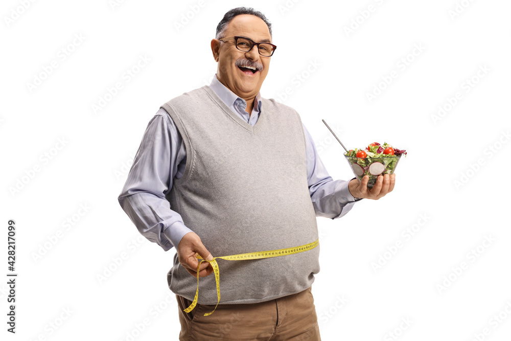 Mature man eating a salad and measuring his waist Mature man eating a salad and measuring his waist