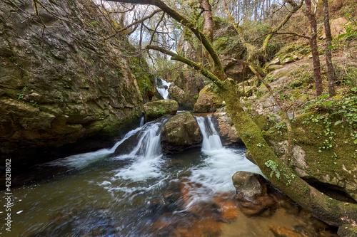 Small waterfall in the middle of the beautiful forest captured in Galicia, Spain photo