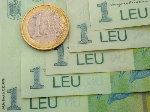 One euro coin put on Romanian banknotes of one leu background photo