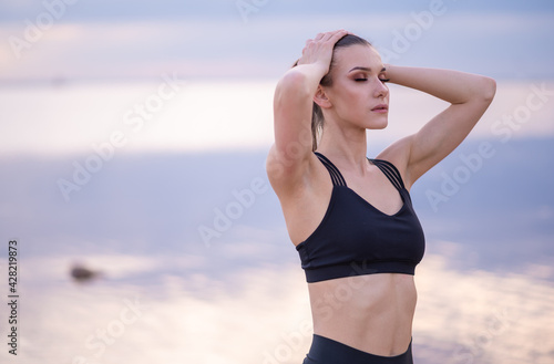  portrait of a beautiful fitness model on a background of the sea at sunset © kalinichenkod