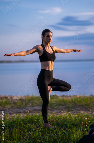 sports girl doing yoga on the beach. Girl with exercise mat