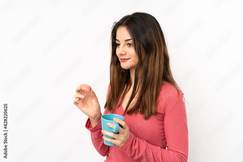 Young caucasian woman isolated on pink background holding colorful French macarons and a cup of milk Young caucasian woman isolated on pink background holding colorful French macarons and a cup of milk