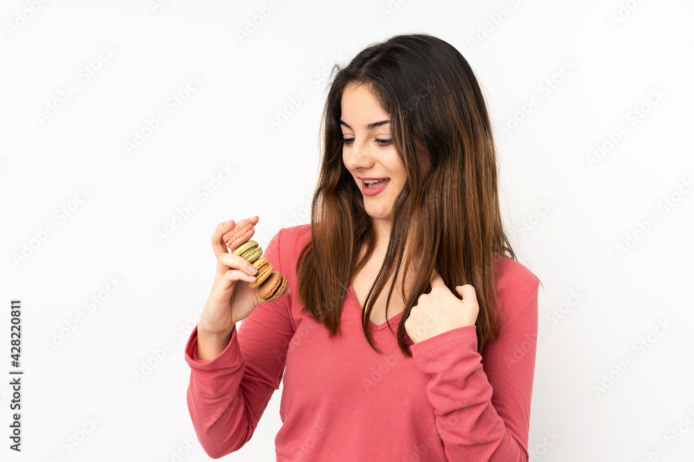 Young caucasian woman isolated on pink background holding colorful French macarons and celebrating a victory Young caucasian woman isolated on pink background holding colorful French macarons and celebrating a victory