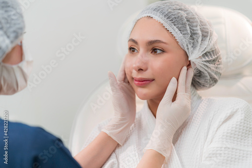 A beautician doing beauty treatment for young woman at clinic
