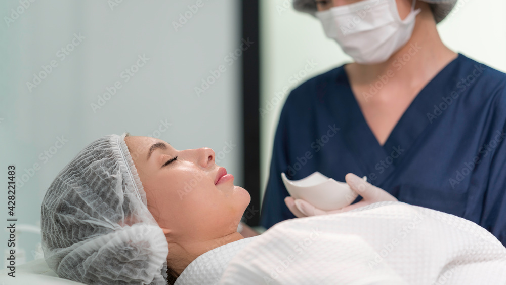 Obraz premium A beautician doing beauty treatment for young woman at clinic