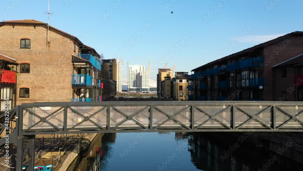 Aerial establishing shot of Public residencial housing with footpath bride and water, slide reveal aerial Aerial establishing shot of Public residencial housing with footpath bride and water, slide reveal aerial