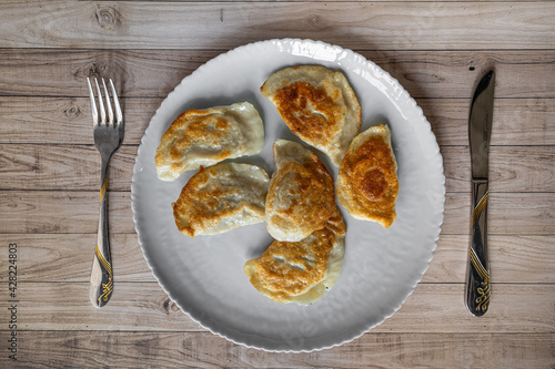 Roasted Varenyky, vareniki, pierogi, pyrohy or dumplings, filled with cheese and potatoes, on a grey gray plate