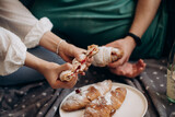 a girl and a guy are preparing croissants with a filling for breakfast close-up