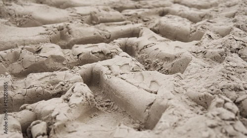 camera slide over tractor tracks left on the sandy ground
