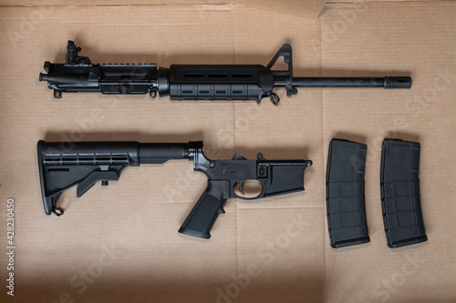 Broken down AR-15 upper and lower receiver semi-auto assault rifle gun with a 30 round magazine photo