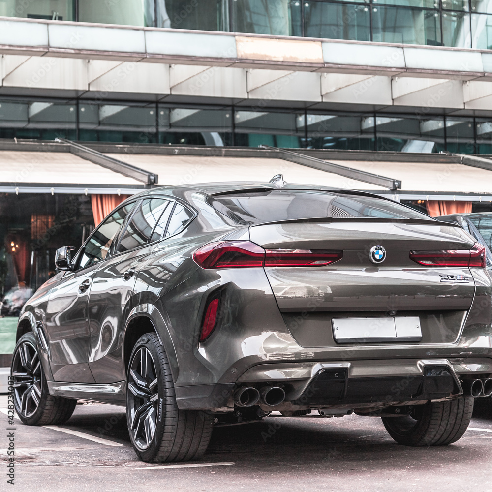 Brand new BMW X6M back view. Sport SUV coupe beige color against a