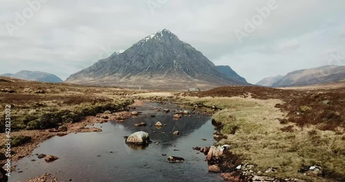 4k aerial footage moving backwards to show Buachaille Etive Mor mountain reflected in water of River Coe. Scottish Highlands, UK. photo
