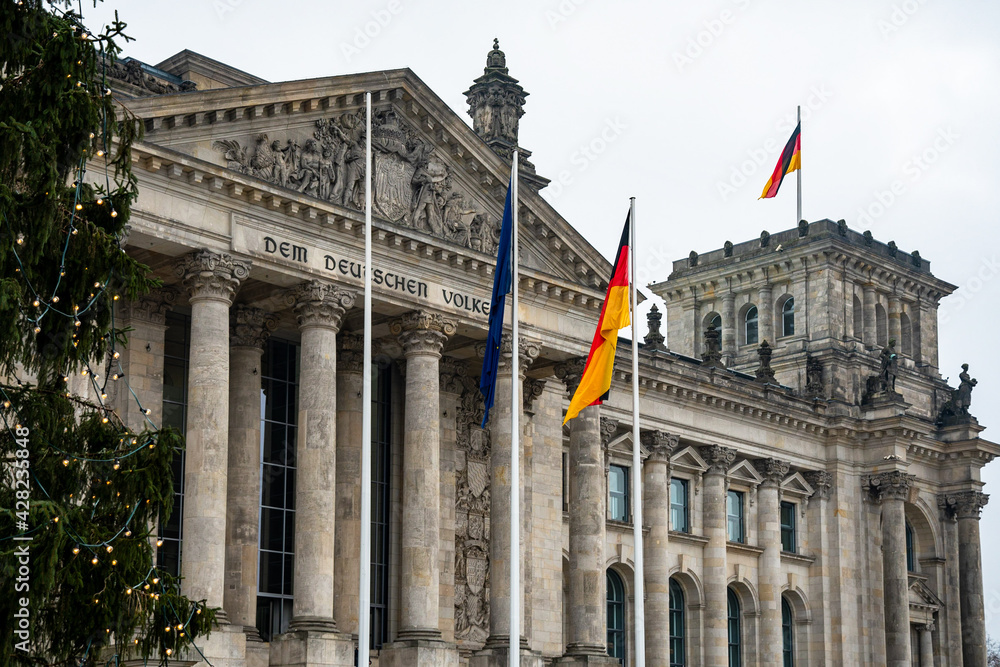 Obraz premium View of the Reichstag building with a Christmas tree in Berlin, Germany. It has been the seat of the German parliament since 1999. 