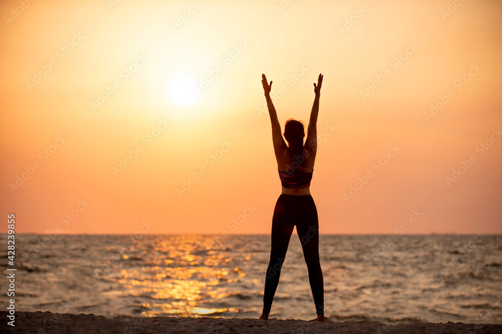 Photo silhouette of woman exercise pose on the sunset beach in holiday vacation summer.