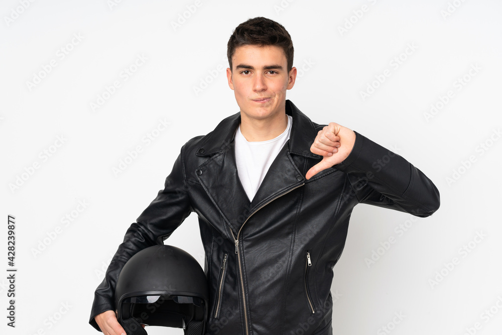Man holding a motorcycle helmet isolated on white background showing thumb down sign Man holding a motorcycle helmet isolated on white background showing thumb down sign
