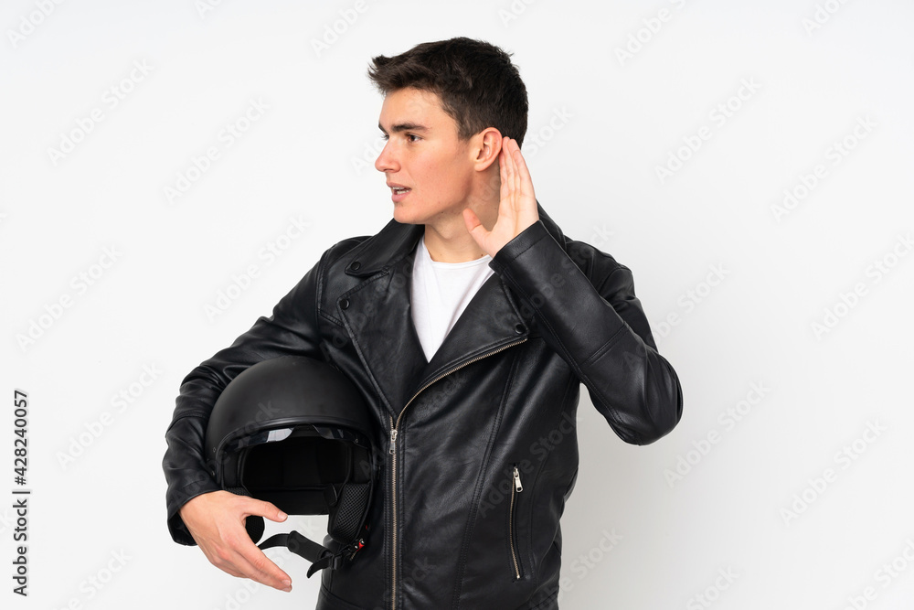 Man holding a motorcycle helmet isolated on white background listening something Man holding a motorcycle helmet isolated on white background listening something