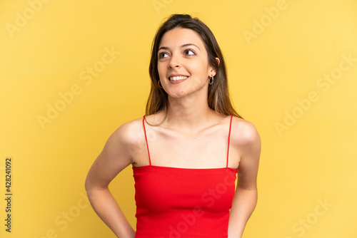 Young caucasian woman isolated on yellow background thinking an idea while looking up