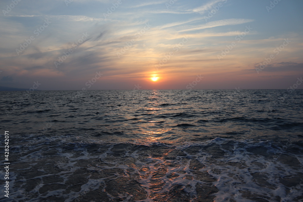 Seascape sunset on a cloudy summer day on the sea coast of Calabria, Italy Seascape sunset on a cloudy summer day on the sea coast of Calabria, Italy