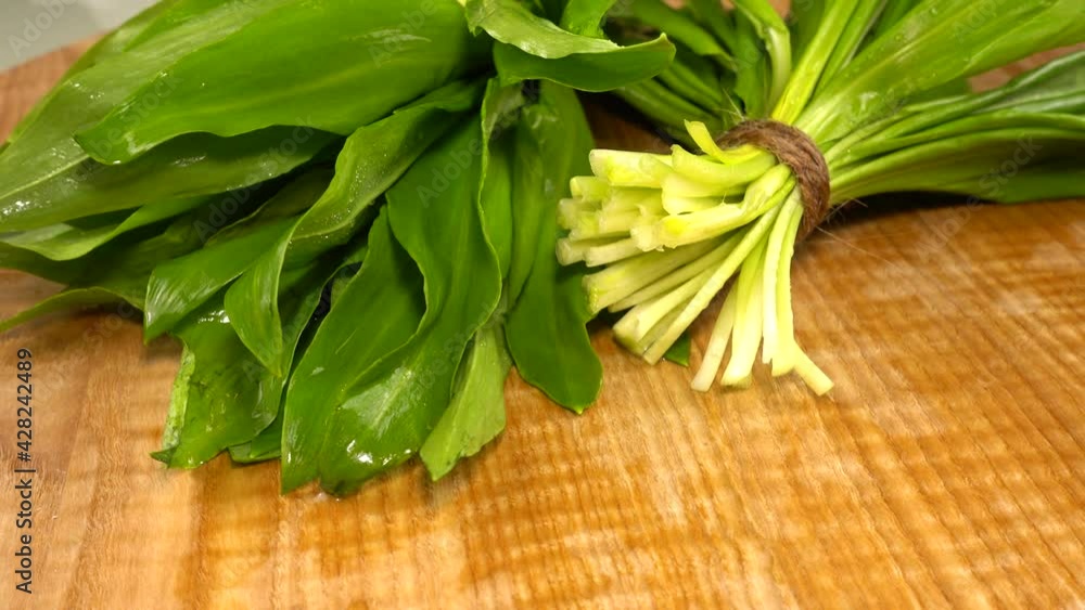 Wild garlic leaves on a wooden cutting board. Wild garlic leaves on a wooden cutting board.