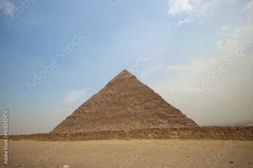 Pyramid of Khafre at Giza Necropolis near Cairo Egypt behind ancient stone wall.