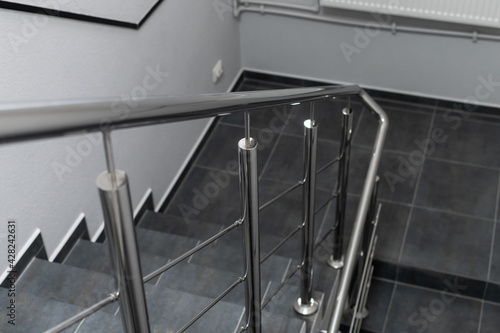 Stainless steel handrails and staircase in office premise, selective focus.