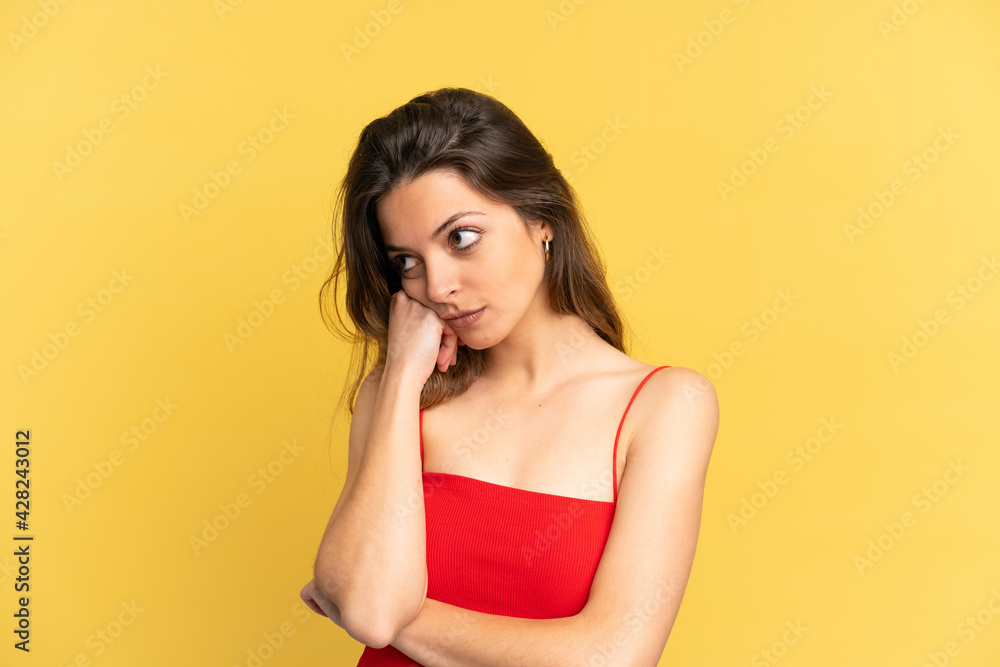Young caucasian woman isolated on yellow background with tired and bored expression Young caucasian woman isolated on yellow background with tired and bored expression