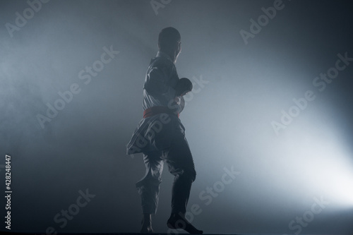 Young black belt fighter training karate in gym