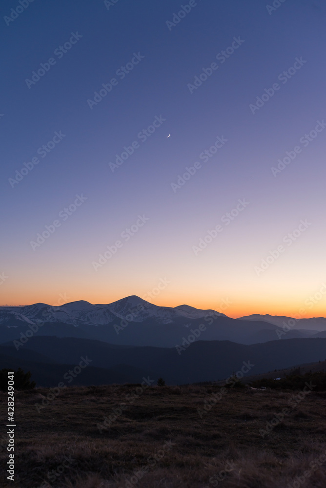 Vertical landscape view of clear twilight sky with rescent Moon