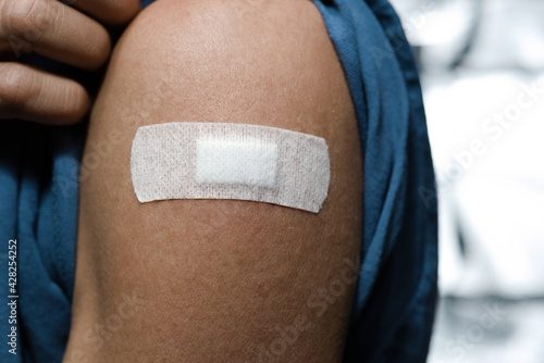 Person mit Pflaster auf Arm nach Injektion Schutzimpfung Medikament Impfen Impfung  photo