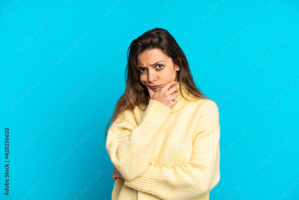 Young caucasian woman isolated on blue background having doubts Young caucasian woman isolated on blue background having doubts