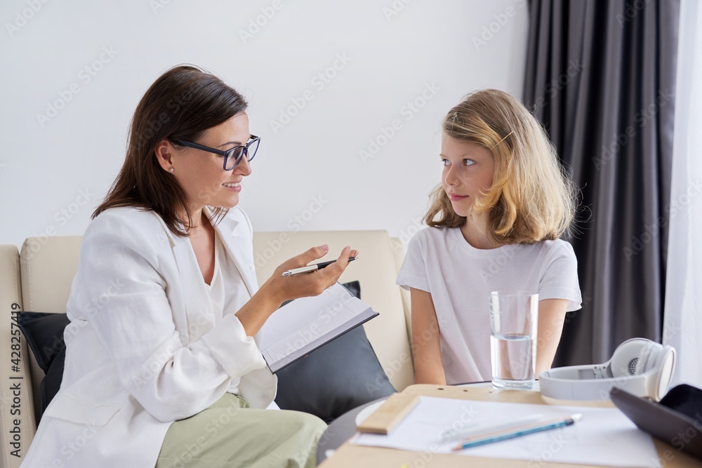 Girl child at session with female psychologist counselor social worker in office Girl child at session with female psychologist counselor social worker in office