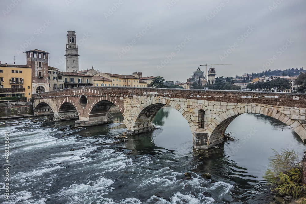 View of Stone Bridge (Ponte Pietra or Pons Marmoreus) - Roman arch bridge crossing the Adige River in Verona, Italy. The bridge completed in 100 BC, is the oldest bridge in Verona.
