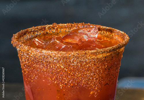 close up of iced clamato drink with salt and hot chili photo