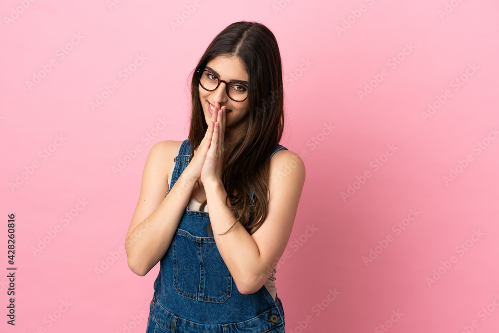 Young caucasian woman isolated on pink background keeps palm together. Person asks for something Young caucasian woman isolated on pink background keeps palm together. Person asks for something