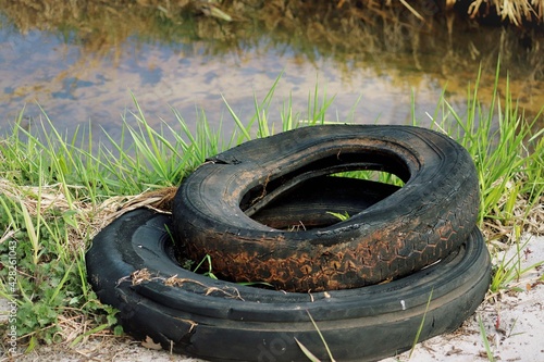 abandoned worn-out tires on the bank of the river
