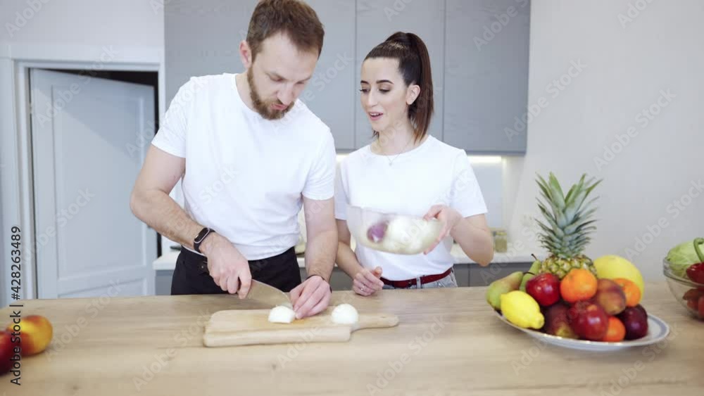 Couple Cooking Together At Home In The Kitchen Young cheerful couple cooking together at home in the kitchen. Healthy food diet and nutrition. Couple Cooking Together At Home In The Kitchen Young cheerful couple cooking together at home in the kitchen. Healthy food diet and nutrition.