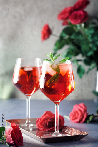 Two alcohol cocktails set with red roses