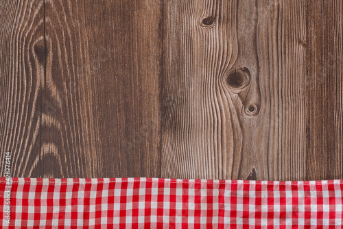 Rustic wooden background with red checkered napkin - Text space