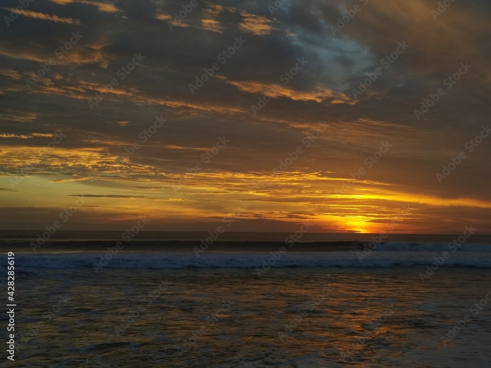 Beautiful cloudy sunset at Kuta beach, Bali, Indonesia. Kuta is the famous beach in Bali island. 