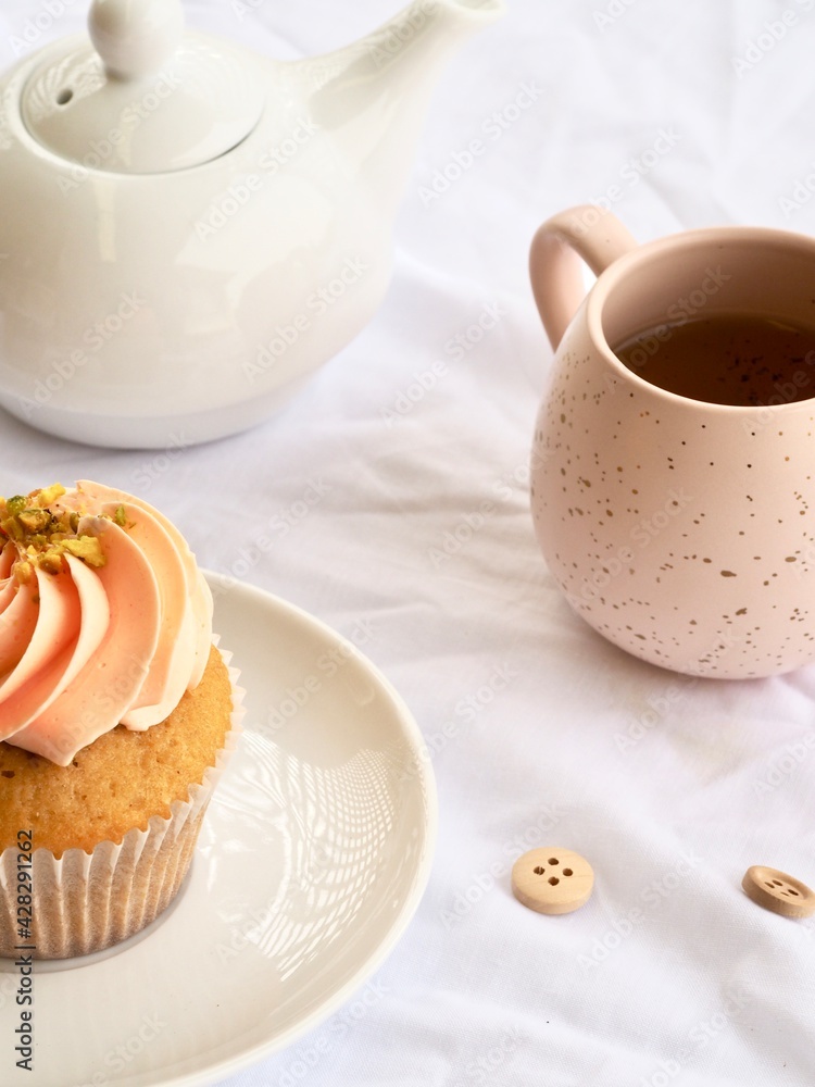 Pretty pink cupcake and pink bug with white teapot on a white background Pretty pink cupcake and pink bug with white teapot on a white background