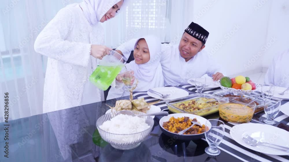 Muslim woman serving fresh drink to her family Muslim woman serving fresh drink to her family