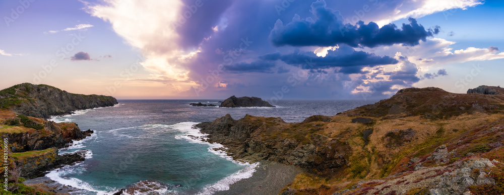 Striking panoramic seascape view on a rocky Atlantic Ocean Coast during a vibrant sunset. Dramatic Sky Art Render. Taken at Crow Head, North Twillingate Island, Newfoundland and Labrador, Canada.