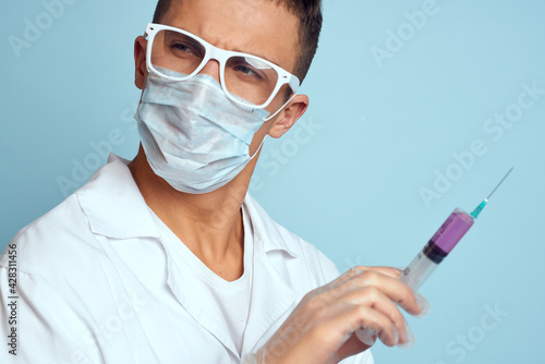 Male doctor white coat treatment medical instruments blue background