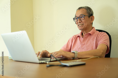 Technology concept, senior citizen using laptop at home