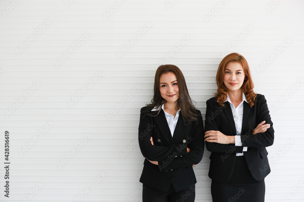 Confident Asian businesswomen against gray wall Confident Asian businesswomen against gray wall