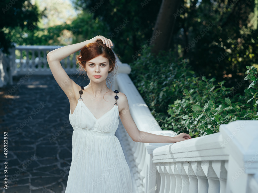 Pretty woman in white dress outdoors green leaves walk model Pretty woman in white dress outdoors green leaves walk model